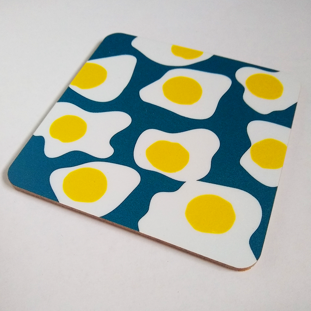 Fried eggs on dark blue background pattern on coaster